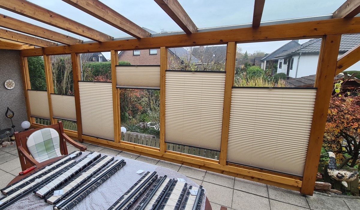 Ein Wintergarten mit Plissees an den Fenstern